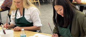 Two young adults painting in the education studio.