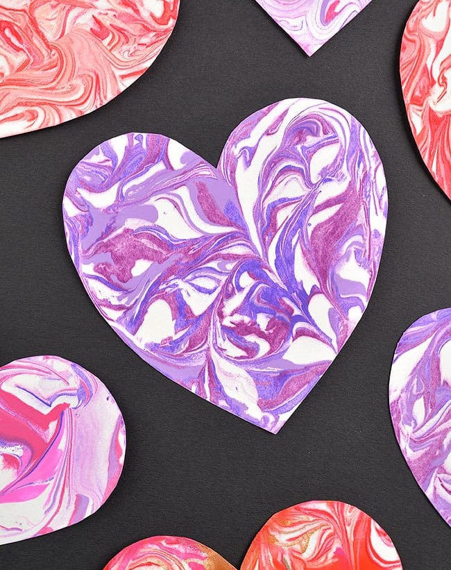 A large purple marbled heart on a black background.