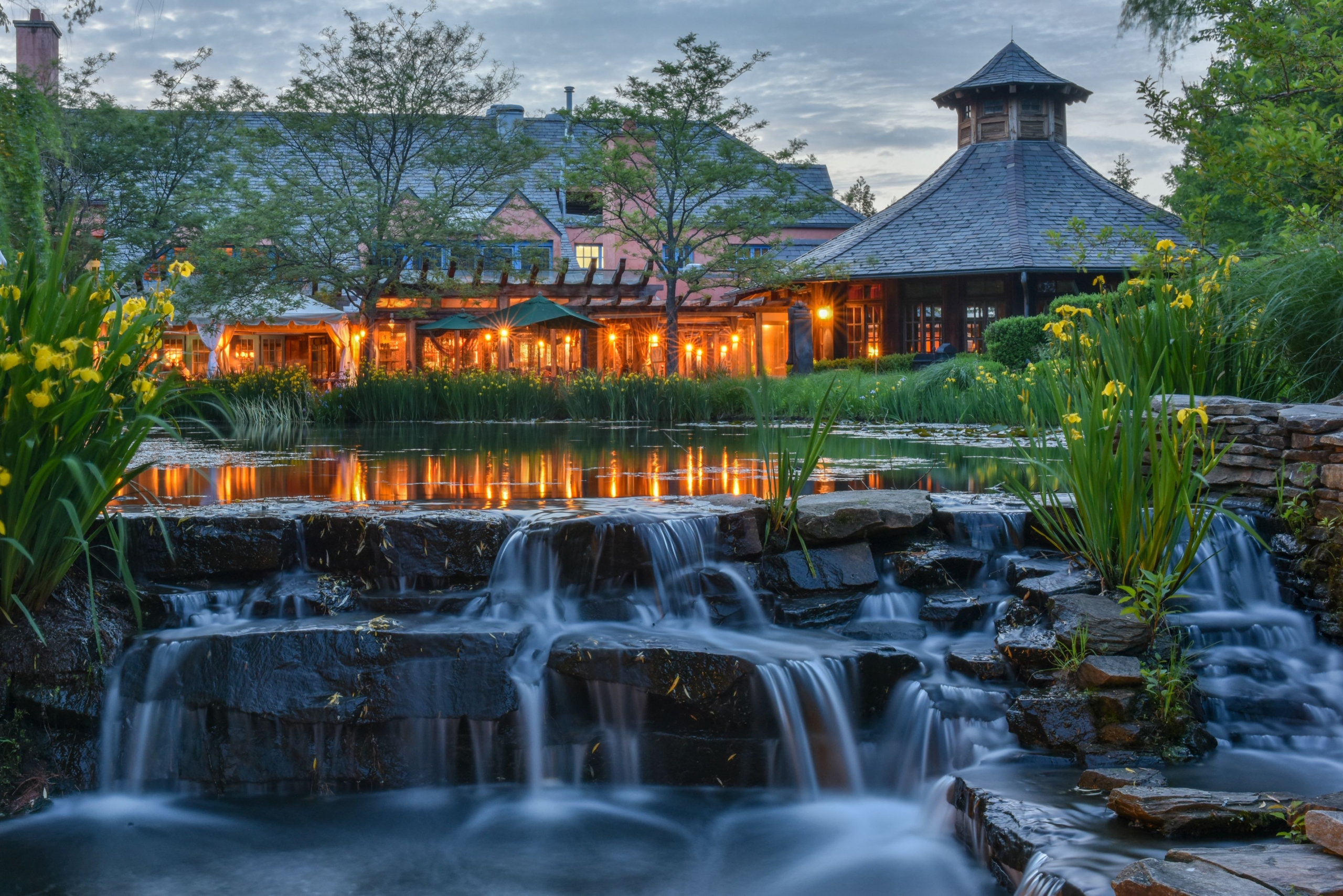 Rat's Pond in the evening. The restaurant is lit up in the background.