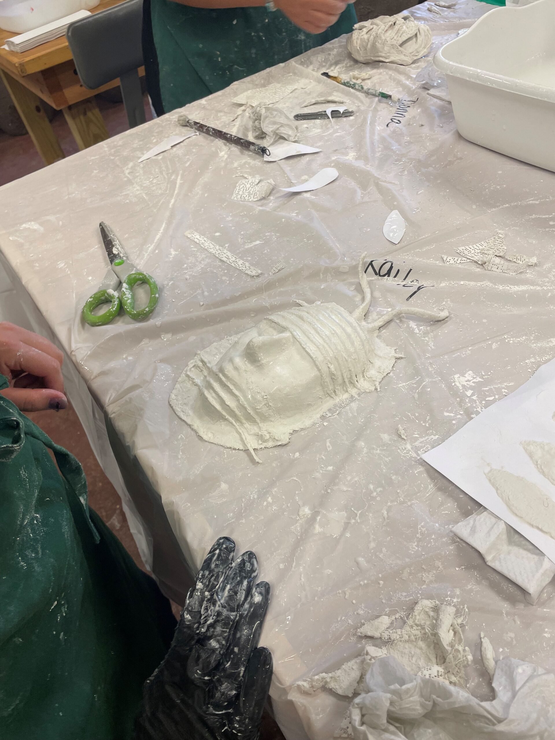 A white plaster mask on a worktable.