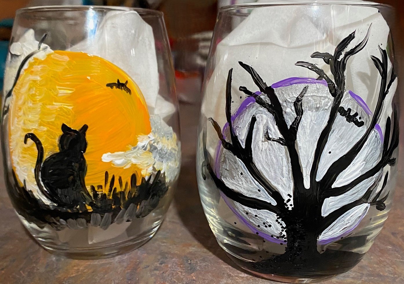 Two wine glasses painted with Halloween designs.