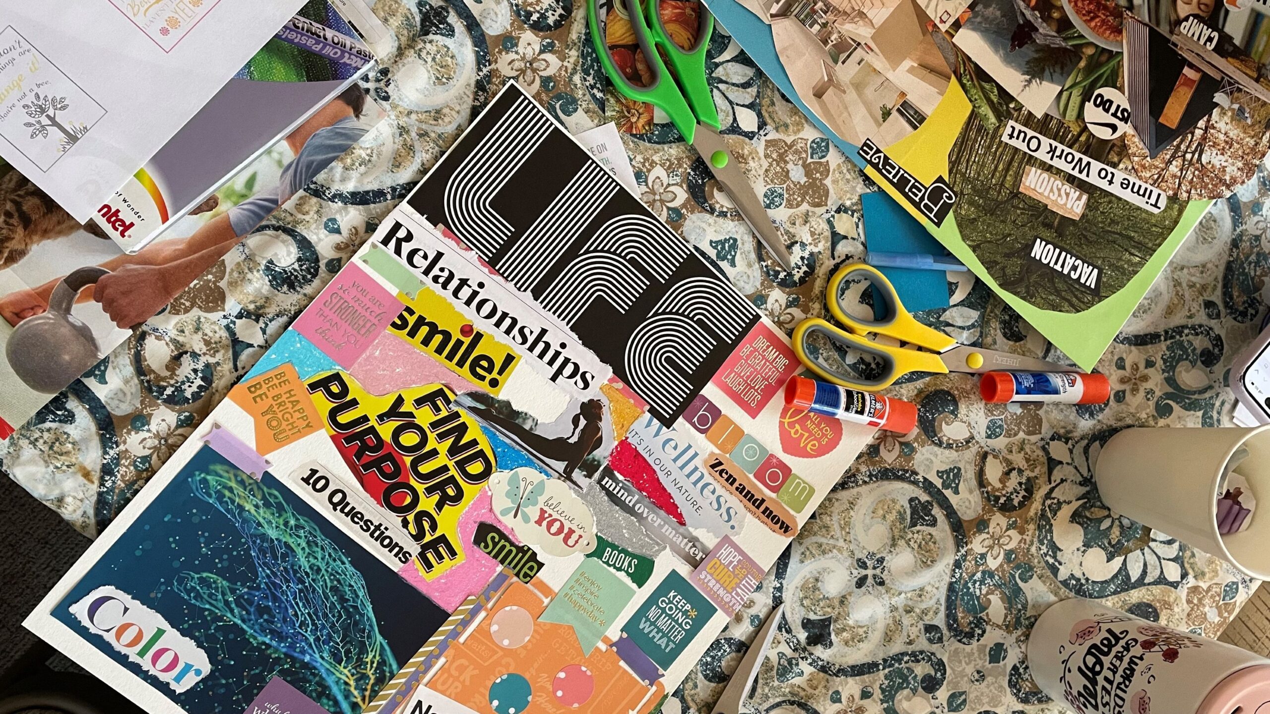 A vision board on a table with crafting supplies.