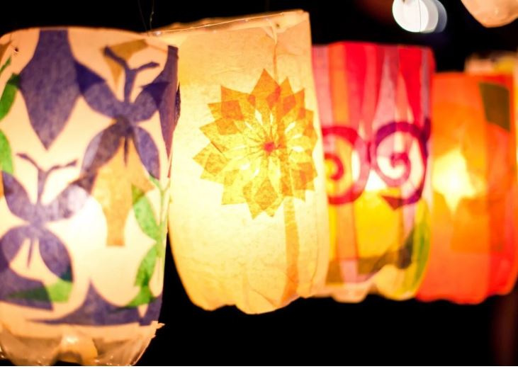 Four glowing paper lanterns with floral designs.
