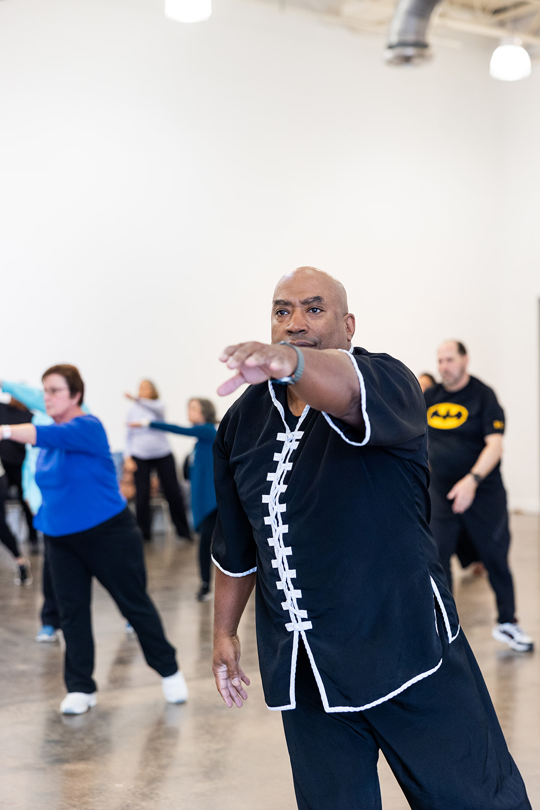 Tony Jackson leads a Tai Chi class indoors.