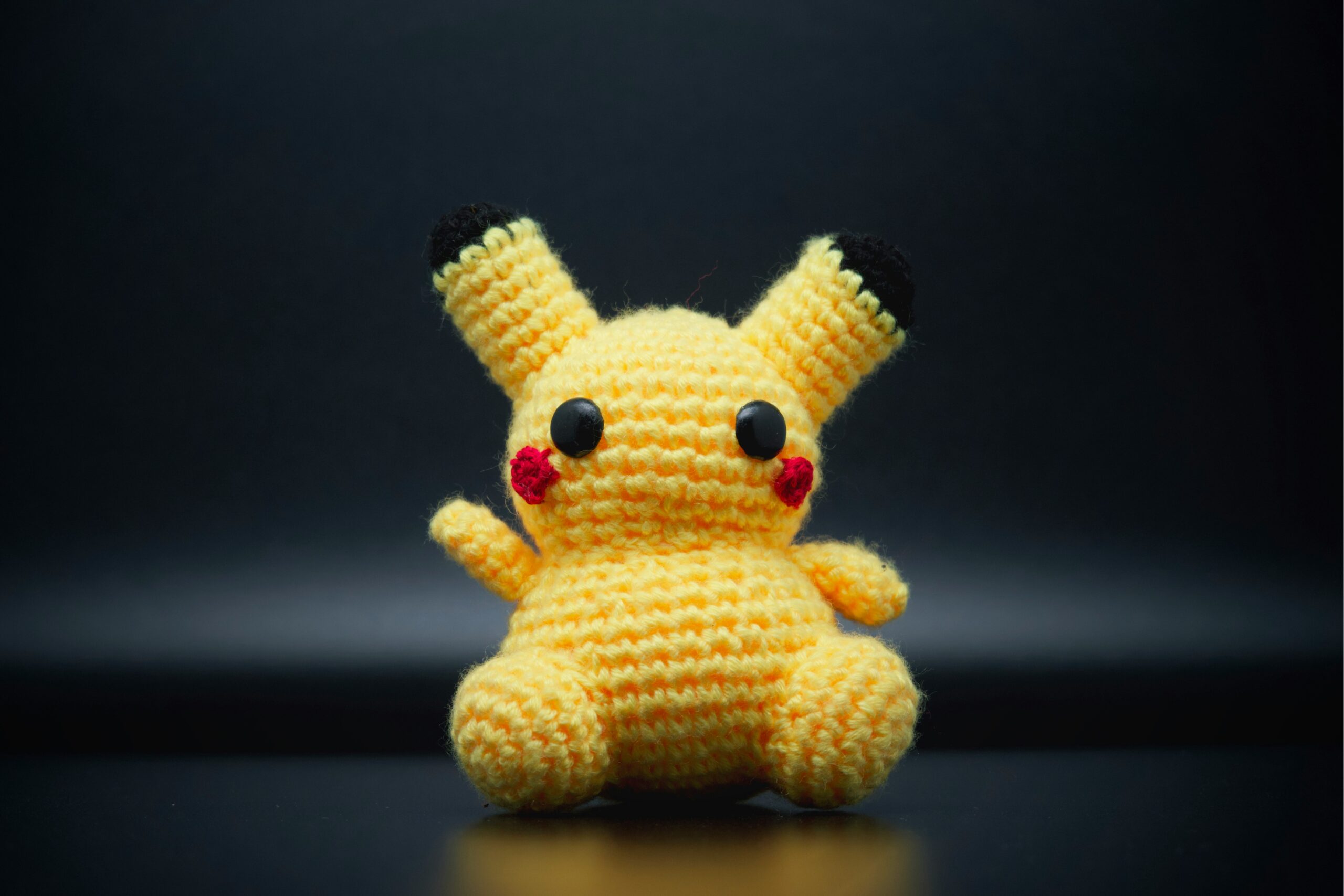 A knitted yellow bear that looks like Pikachu.