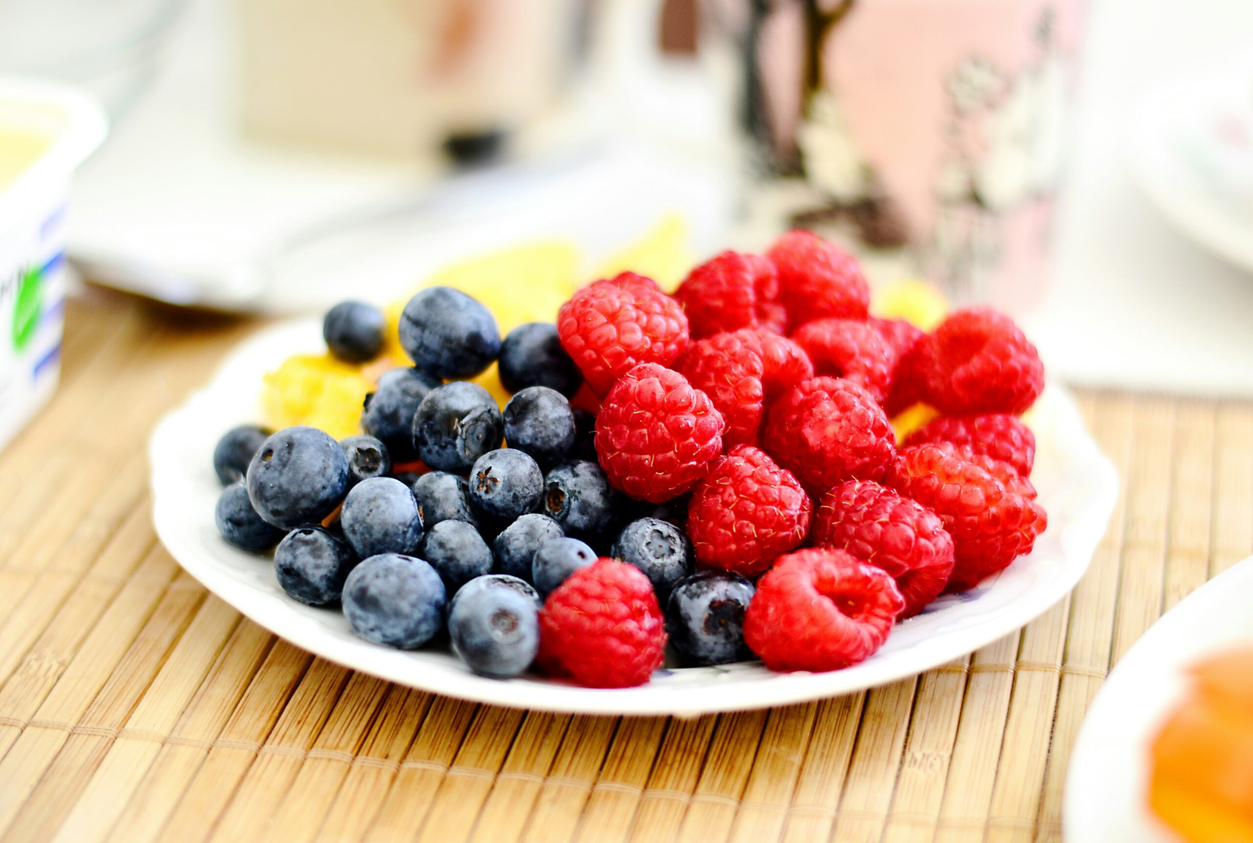 A plate of blueberries and raspberries.