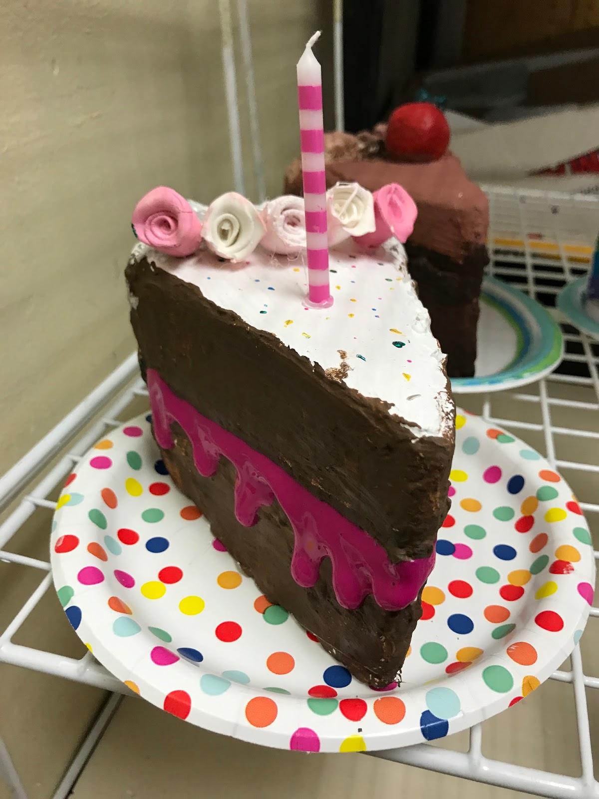 A plaster sculpture of a decorated slice of cake.