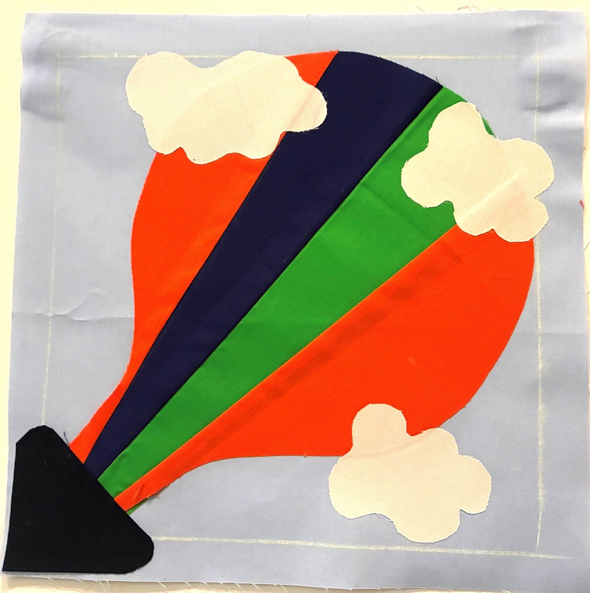 A quilted square with a balloon design.